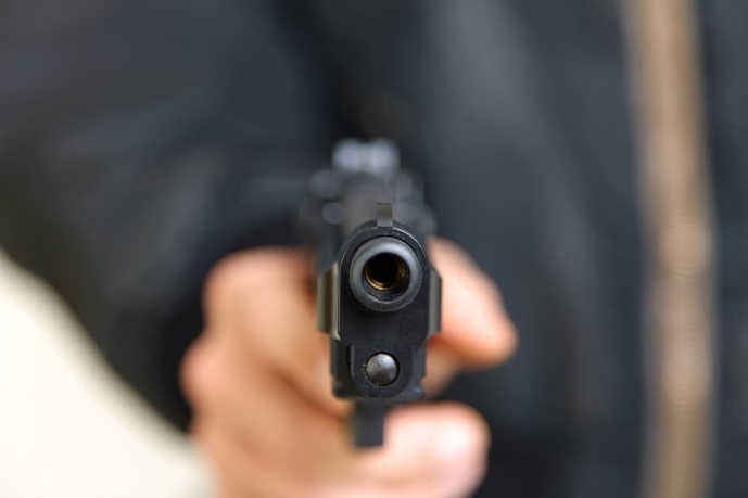 L'individu a d'abord menaçait lke commerçant avec son arme pui lui a asséna un coup de crosse - Illustration © Adobe Stock