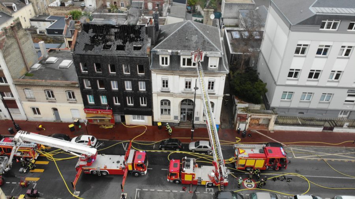 L’incendie a embrasé les combles et la toiture de l’immeuble (façade noire) qui abrite huit appartements et une boulangerie - Photo @ Sdis76