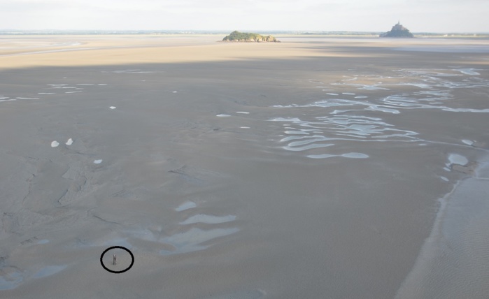 Photo prise depuis l'hélicoptère de la Marine nationale alors que la marée commence à monter. Dans le cercle noir, on aperçoit le jeune homme qui semble attendre Photo prise depuis l'hélicoptère de la Marine nationale alors que la marée commence à monter. Dans le cercle noir, on aperçoit le jeune homme qui semble attendre