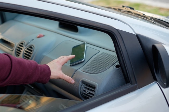 La femme était en train d'attacher son fils à l'arrière du véhicule quand un inconnu lui a dérobé son téléphone portable - Illustration © Adobe Stock