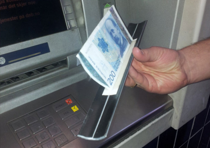 Une fausse trappe en aluminium est glissée dans la fente à billets. Une bande autocollante permet alors de retenir les billets (Photo d'illustration)